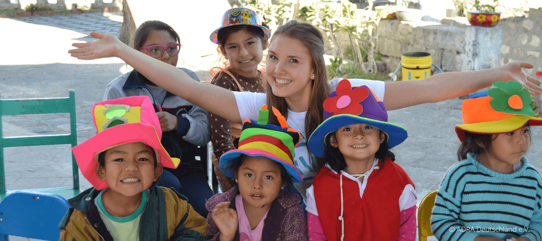 ADRAlive!-Freiwillige Sophia in Peru hat Spaß mit den Kindern, die stolz bunte, selbstgebastelte Hüte tragen