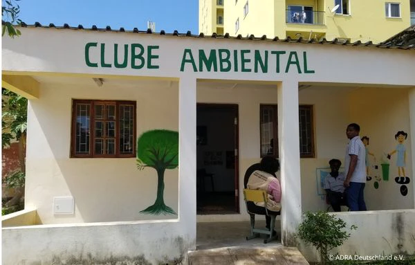 Gebäude des Clube Ambiental in Maputo mit Wandmalereien zum Thema Umwelt und mehreren Personen vor dem Eingang