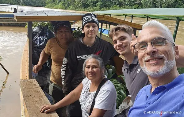 Freiwillige und Caritas-Mitarbeitende machen ein Gruppenfoto auf einem Boot im peruanischen Amazonasgebiet
