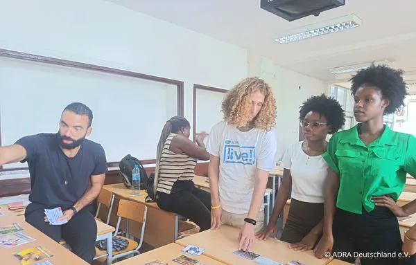 Ein ADRA-Freiwilliger arbeitet mit jungen Erwachsenen in Mosambik an einem Workshop mit Bildkarten