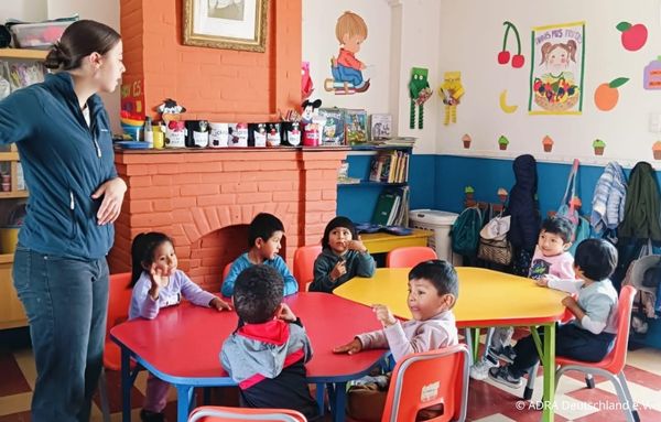 Eine ADRAlive!-Freiwillige betreut mehrere Kleinkinder in Nuestro Hogar in Arequipa