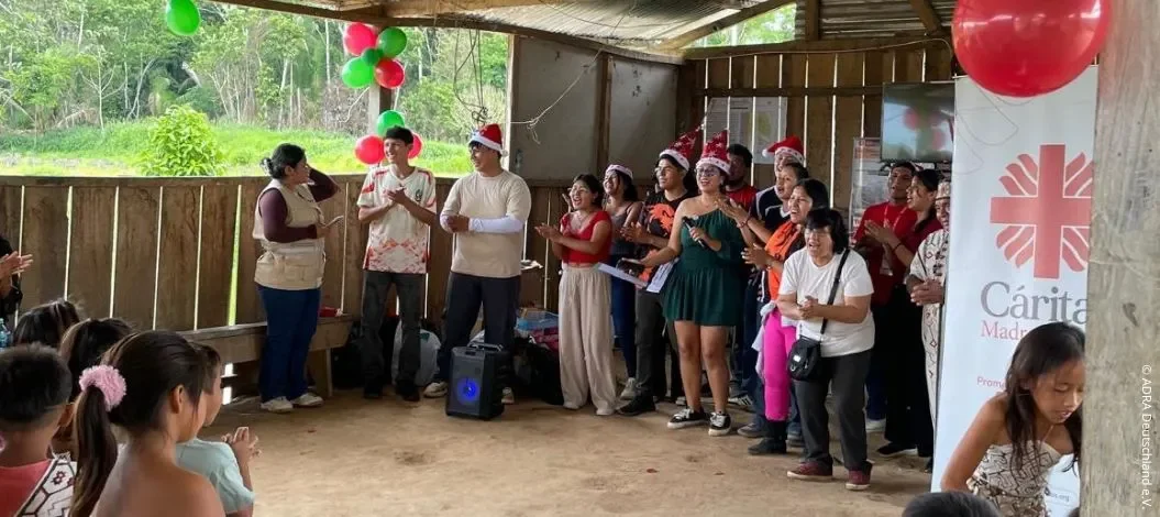 ADRA-Freiwillige und Caritas-Mitarbeitende feiern gemeinsam mit Kindern und Familien in einer indigenen Gemeinschaft in Peru
