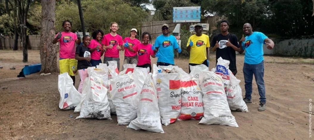 Gruppe bei einer Müllsammelaktion zum World Cleanup Day in Mosambik mit Säcken voller gesammeltem Abfall